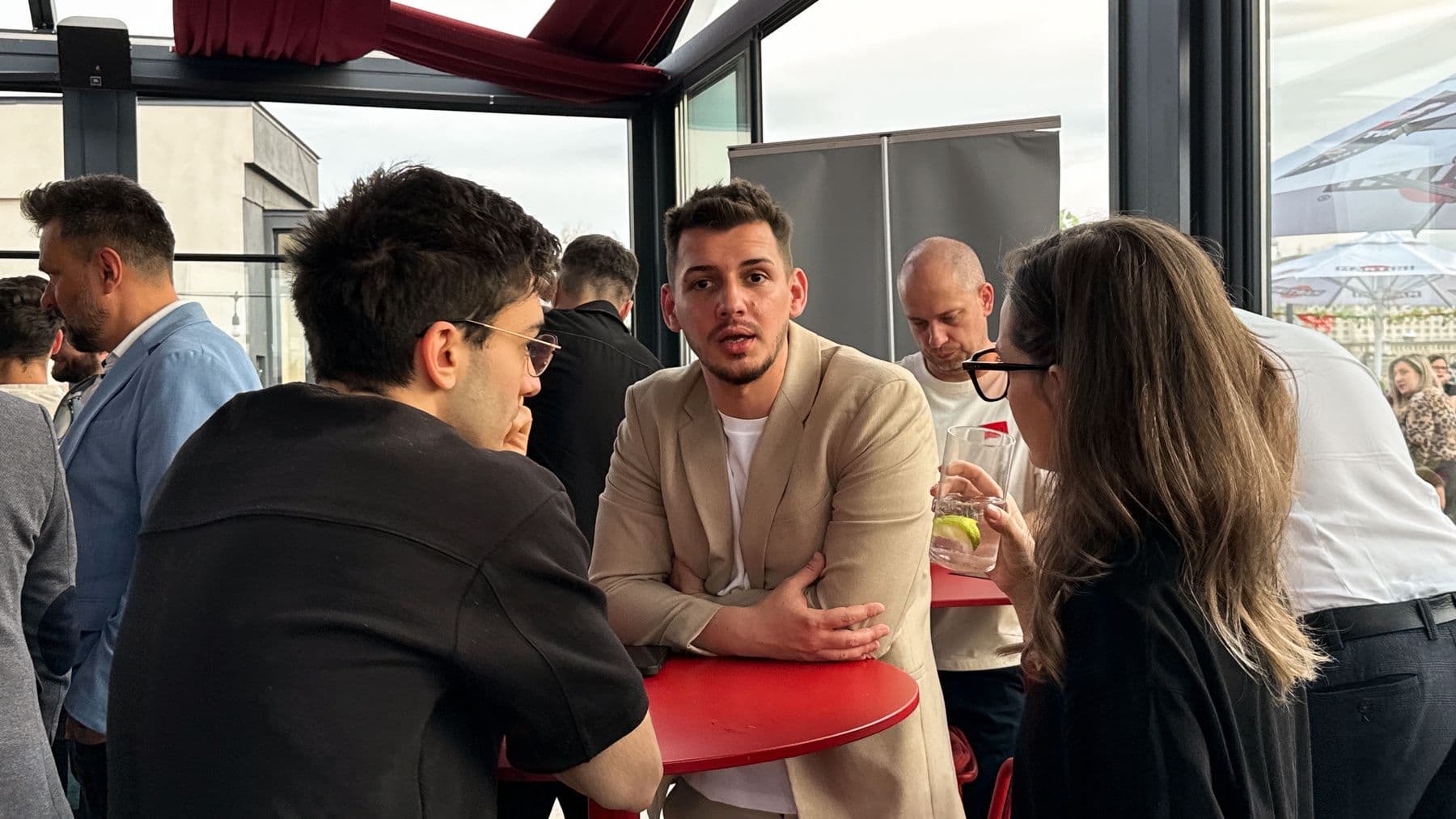 Attendees talking around a table on the BARTINI rooftop