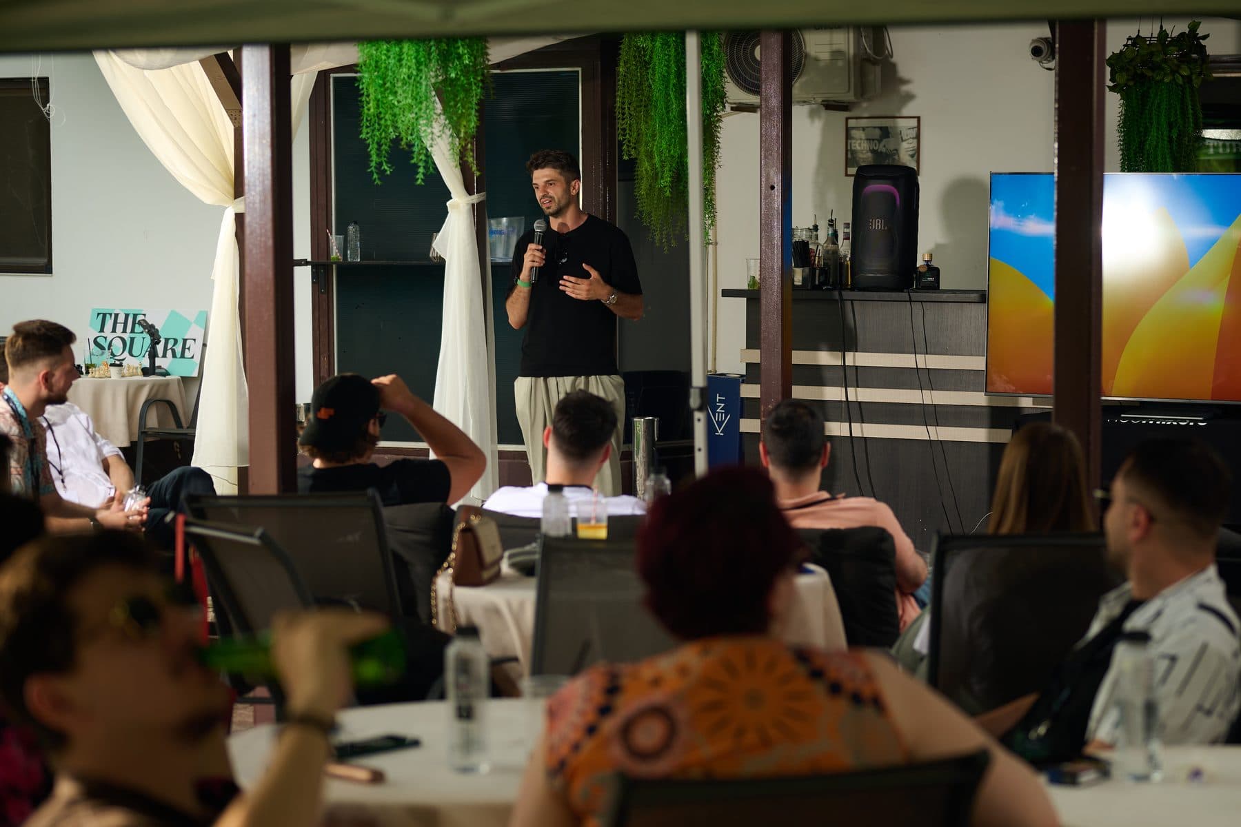 A talk under the tent, slides on the screen — AI House Bucharest, June 2026